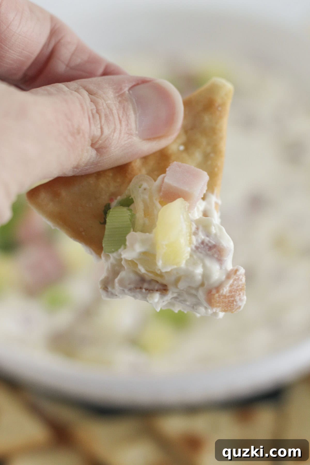 Effortless Hawaiian Ham Dip 8 Scooping Hawaiian dip on a pita cracker.