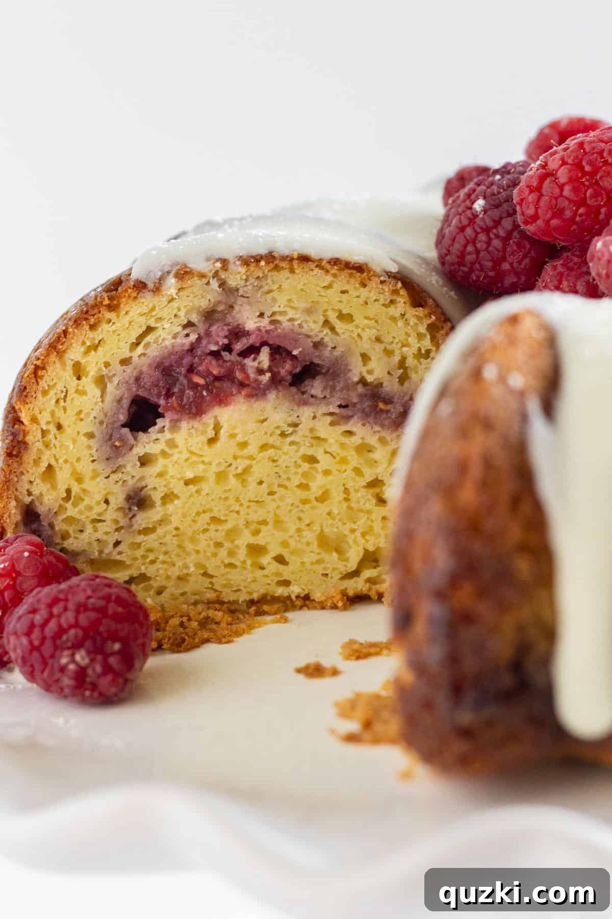 Looking in the inside of a white chocolate raspberry cake with raspberry filling.