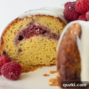 Looking into the inside of a white chocolate and raspberry cake.