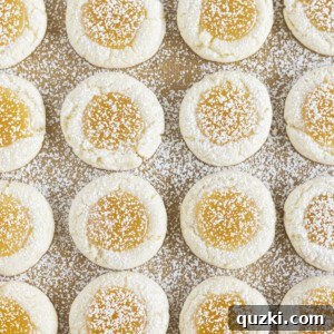 Lemon curd cookies on a sheet pan, dusted with powdered sugar, ready to eat.