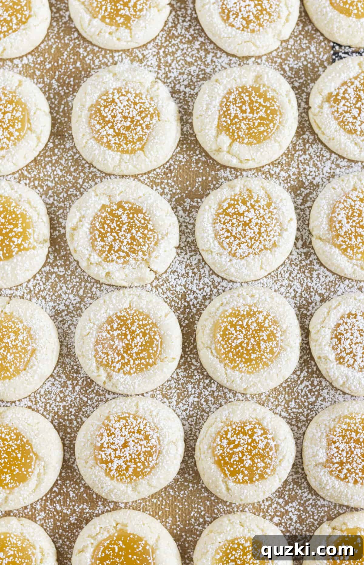 Zesty Lemon Curd Cookies 7 A sheet pan full of freshly baked lemon curd cookies, generously sprinkled with powdered sugar.