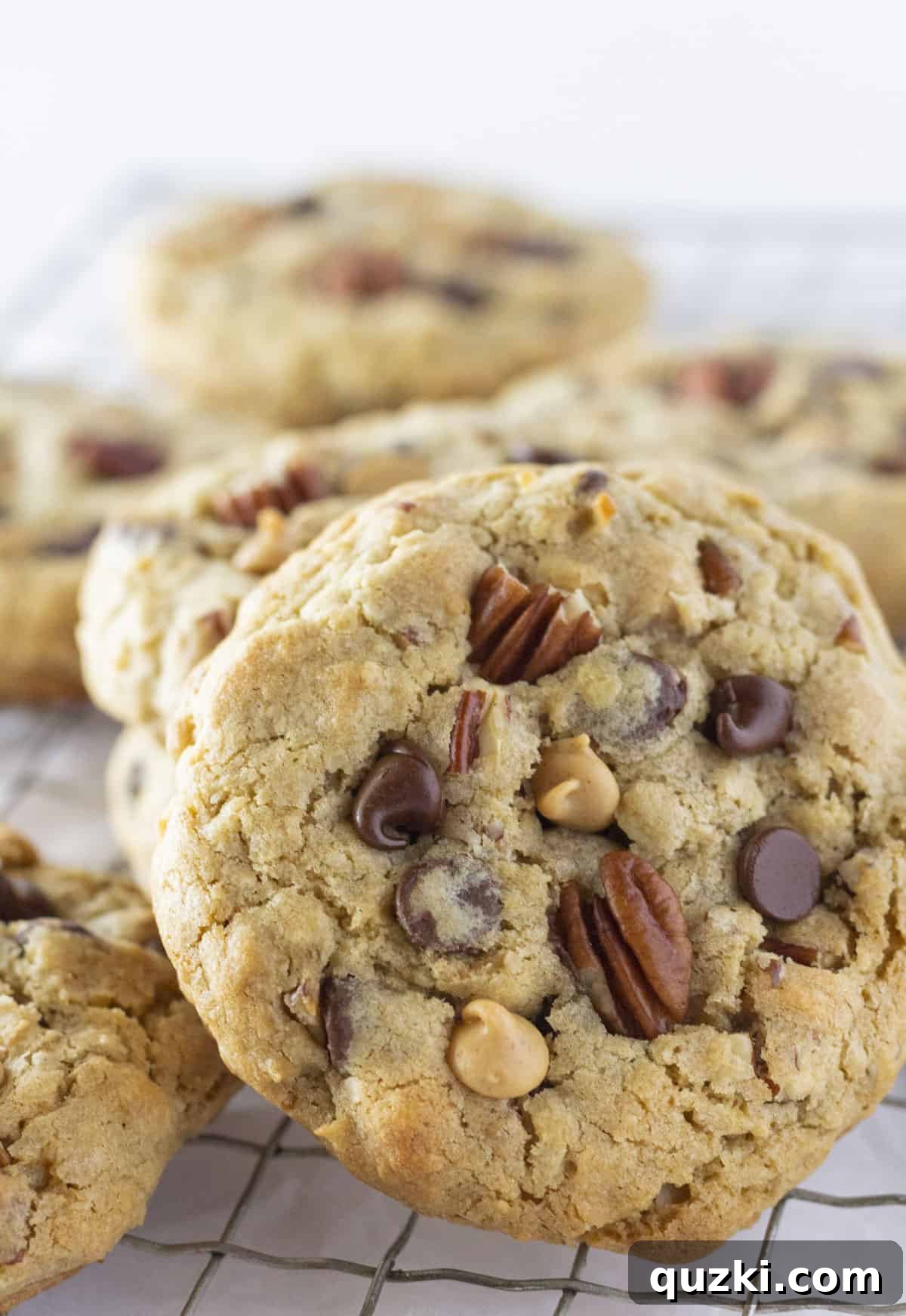 Rancher's Favorite Chewy Cowboy Cookies 2 Stacked chewy Cowboy Cookies on a wire cooling rack, showcasing their hearty texture and rich ingredients.