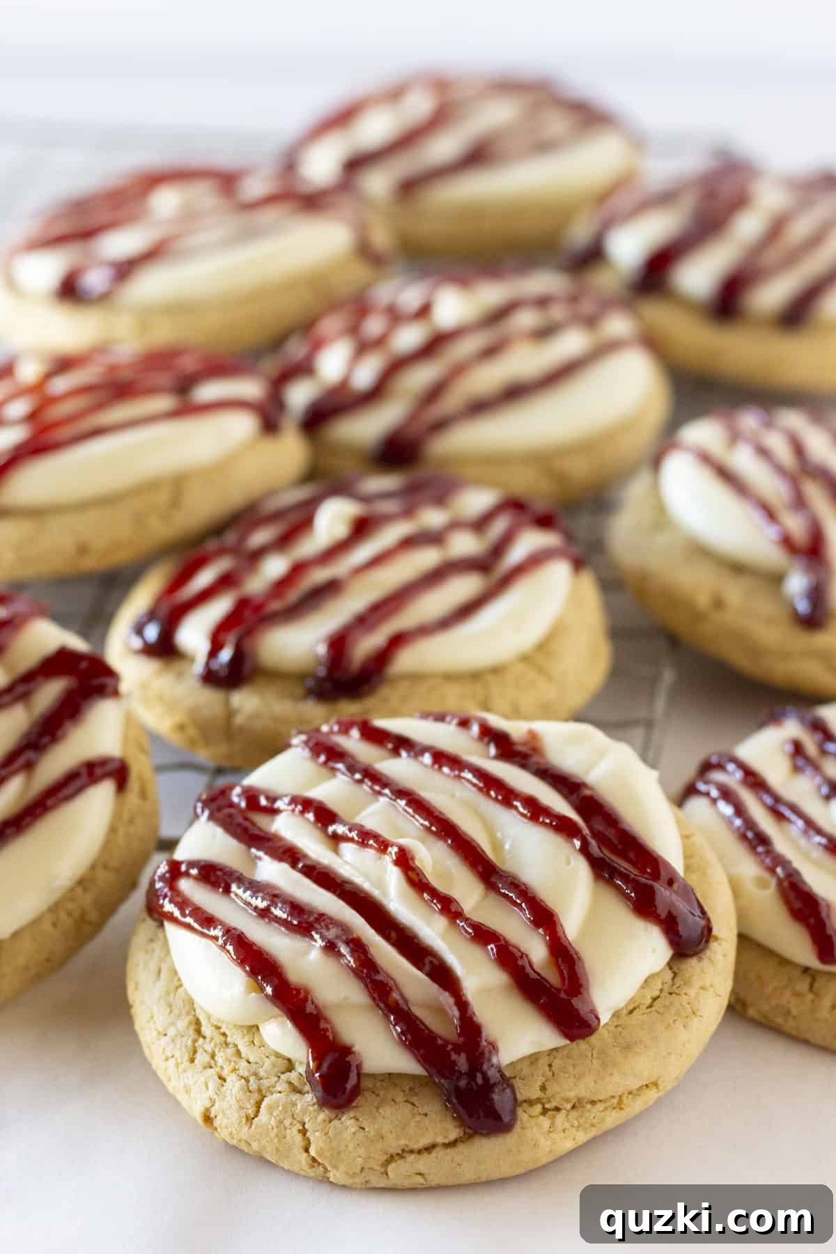 A beautiful close-up shot of several Crumbl Copycat Raspberry Cheesecake Cookies, highlighting the texture and topping.