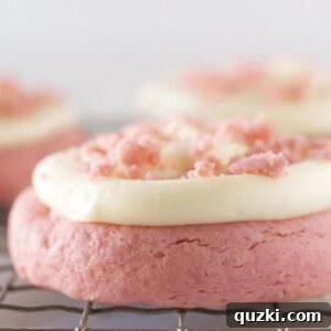 Frosted Pink Velvet Cookies on a cooling rack.
