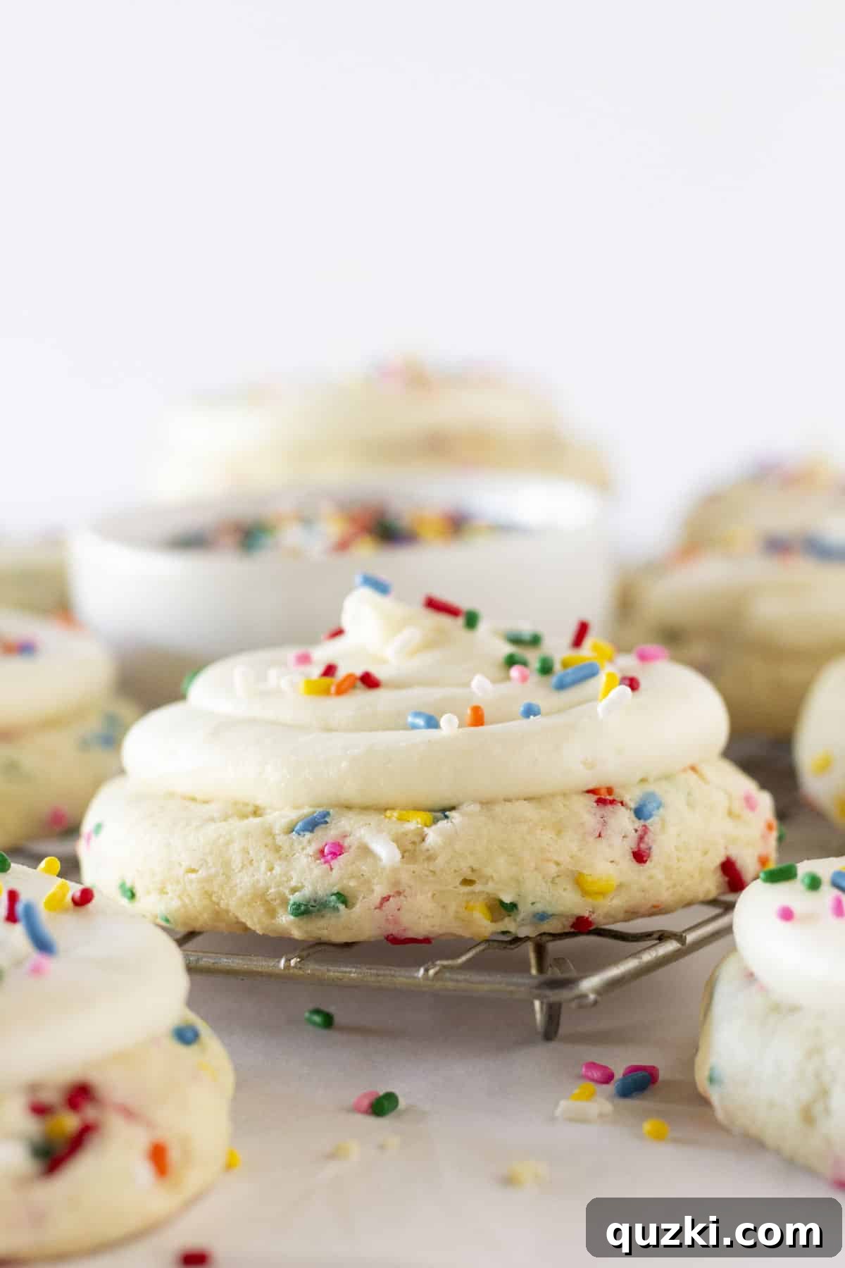Cake Mix Copycat Crumbl Birthday Cake Cookies 2 Birthday Cookies on a wire rack with sprinkles, ready to be enjoyed.