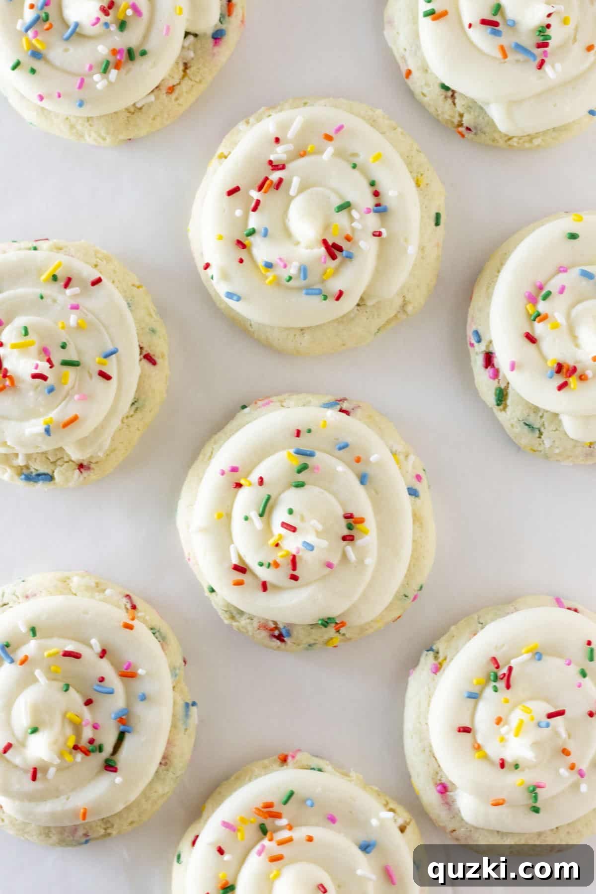 Cake Mix Copycat Crumbl Birthday Cake Cookies 6 Looking down on a dozen beautifully frosted birthday cake cookies, adorned with colorful sprinkles.