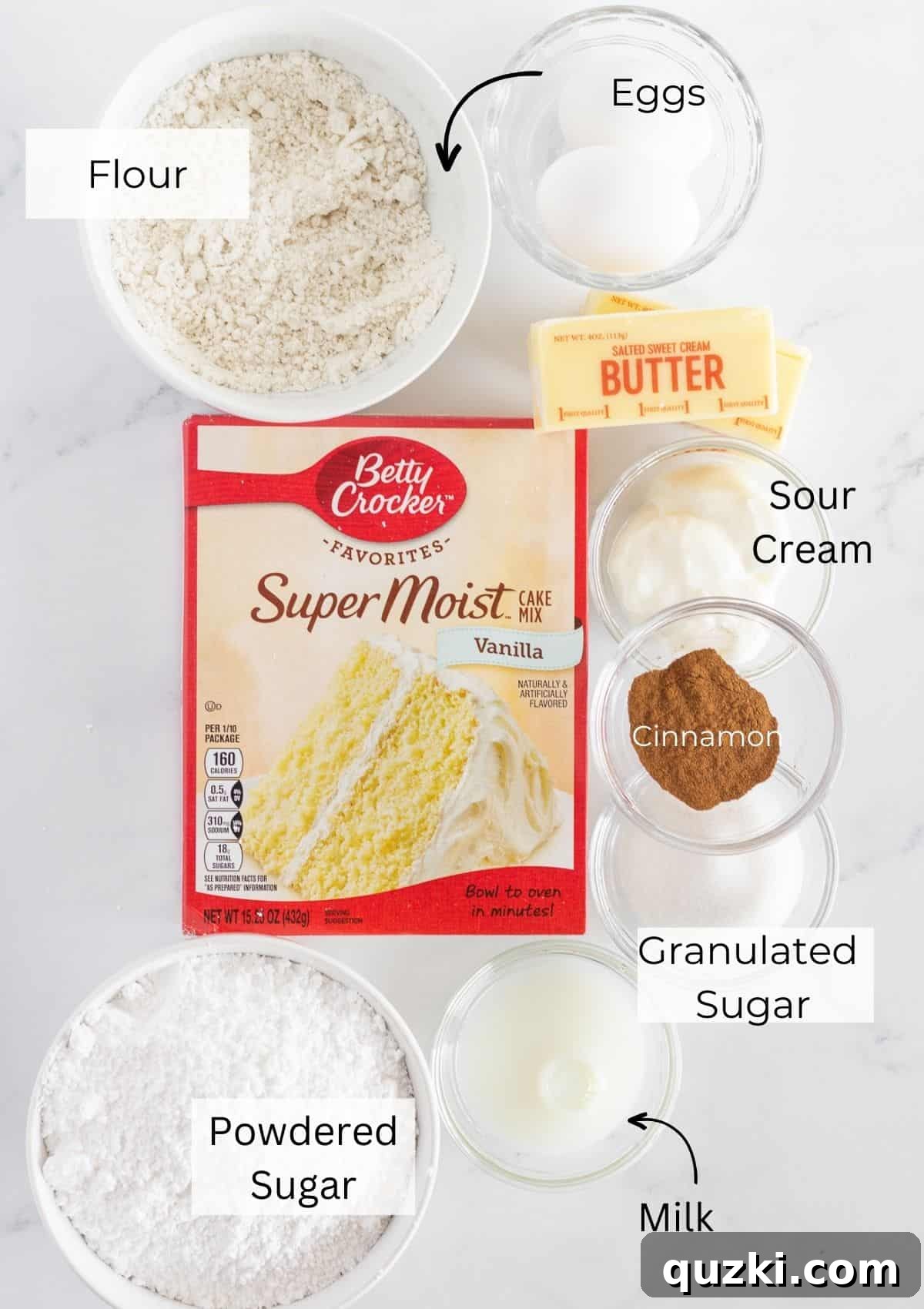 A selection of key ingredients laid out, including vanilla cake mix, flour, eggs, butter, sour cream, and cinnamon, ready for making Copycat Crumbl Churro Cookies.
