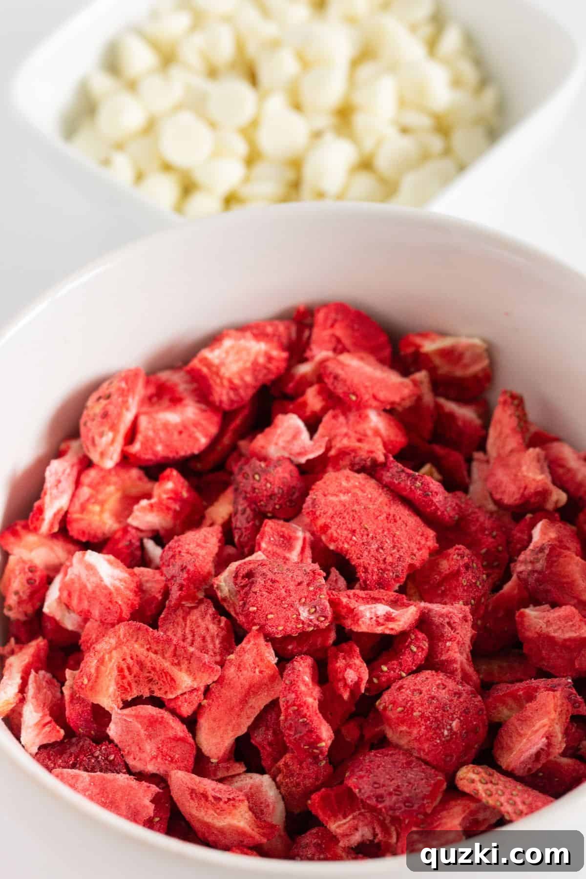 A vibrant display of white chocolate chips and colorful freeze-dried strawberries, ready for baking.