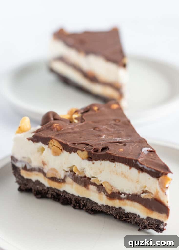Close-up of a slice of Dairy Queen Buster Bar Ice Cream Pie showing layers of crust, ice cream, fudge, and peanuts, by Top US dessert blog Practically Homemade