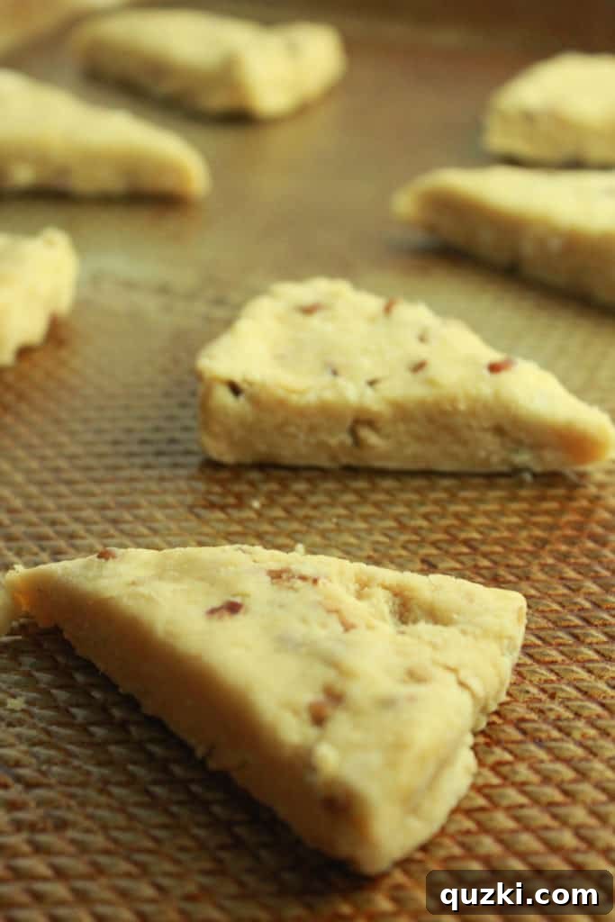 Maple Pecan Bliss Scones 10 Cutting scone dough rounds into triangles and arranging on a baking sheet for freezing.