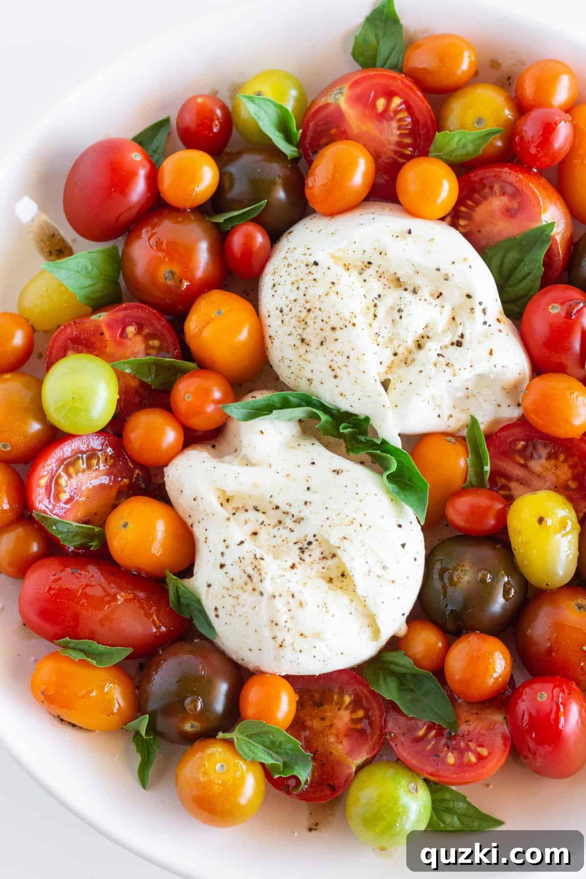 Luscious Burrata Caprese 3 Two fresh balls of burrata cheese on a wooden board, ready to be prepared for a Caprese salad, showcasing its pristine white appearance.