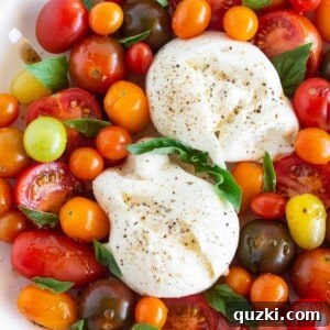 Burrata Caprese salad in a bowl with fresh basil and tomatoes, ready to serve.