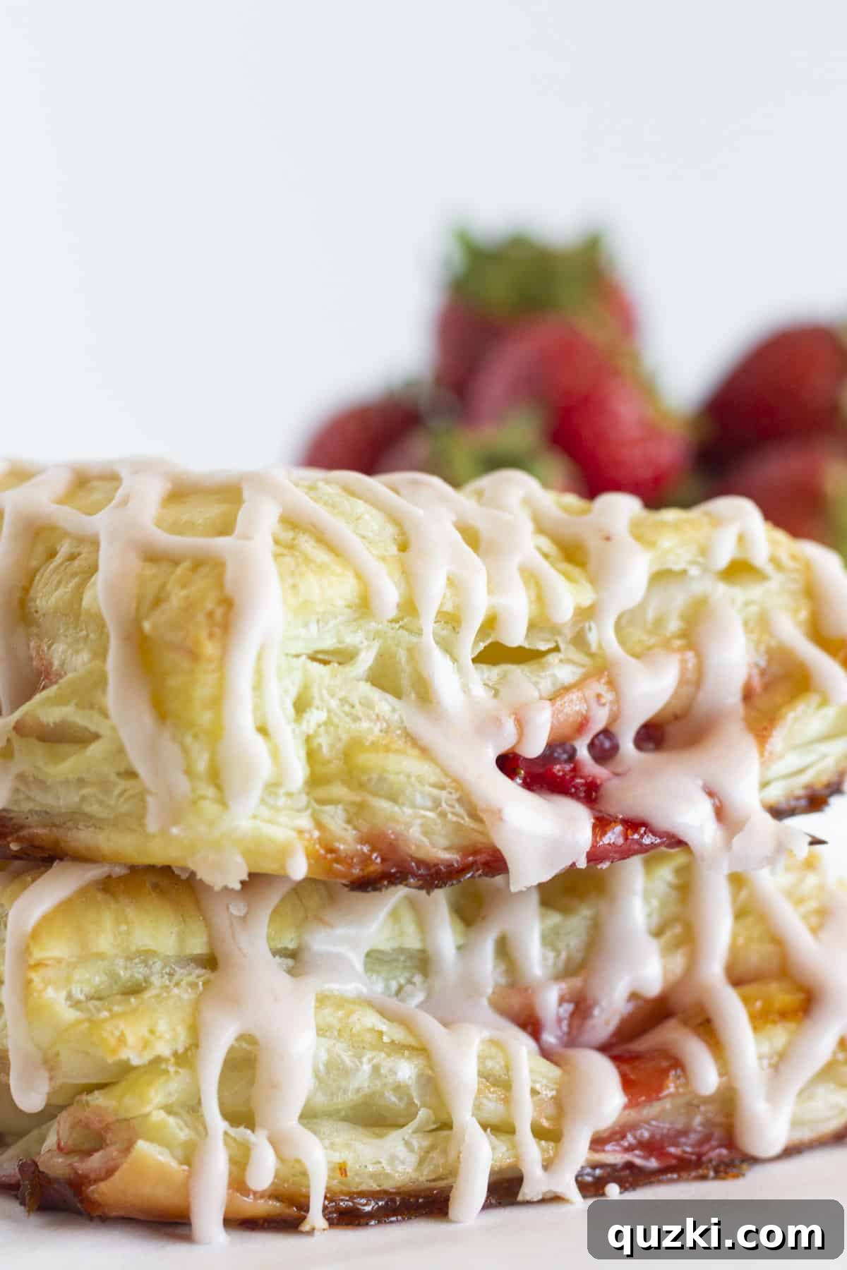 Effortless Strawberry Puff Pastry Delights 7 Two fresh strawberry turnovers stacked on each other.