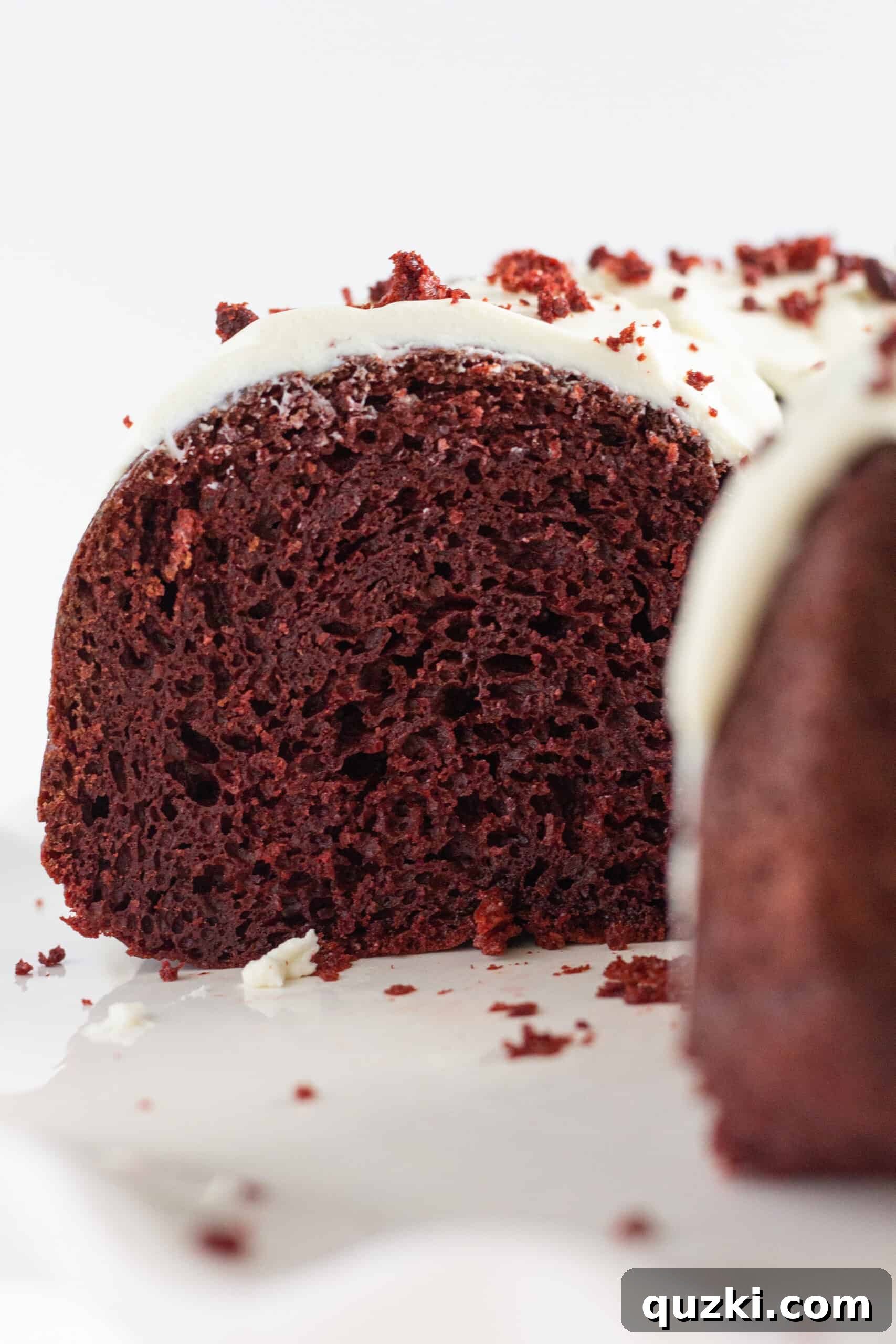 Foolproof Red Velvet Bundt Cake 3 Close-up of a slice of Easy Red Velvet Bundt Cake showing its moist crumb and cream cheese frosting.