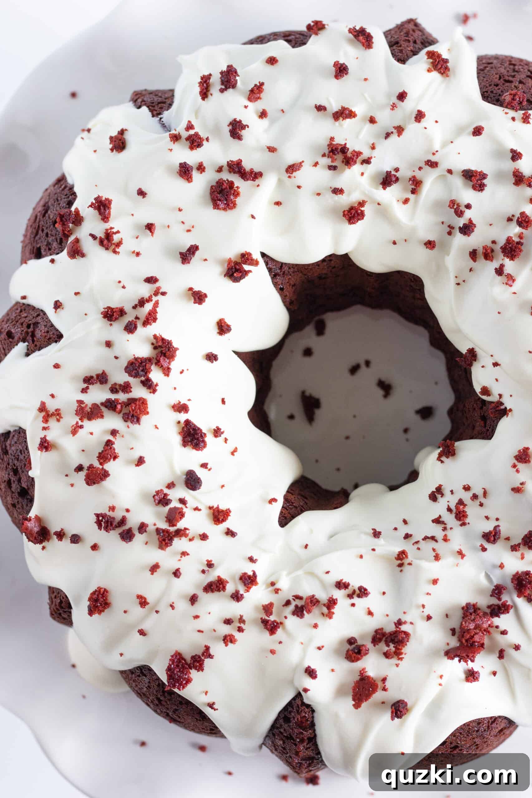 Foolproof Red Velvet Bundt Cake 5 Red Velvet Bundt Cake with a slice taken out, displaying the beautiful red color and white frosting.
