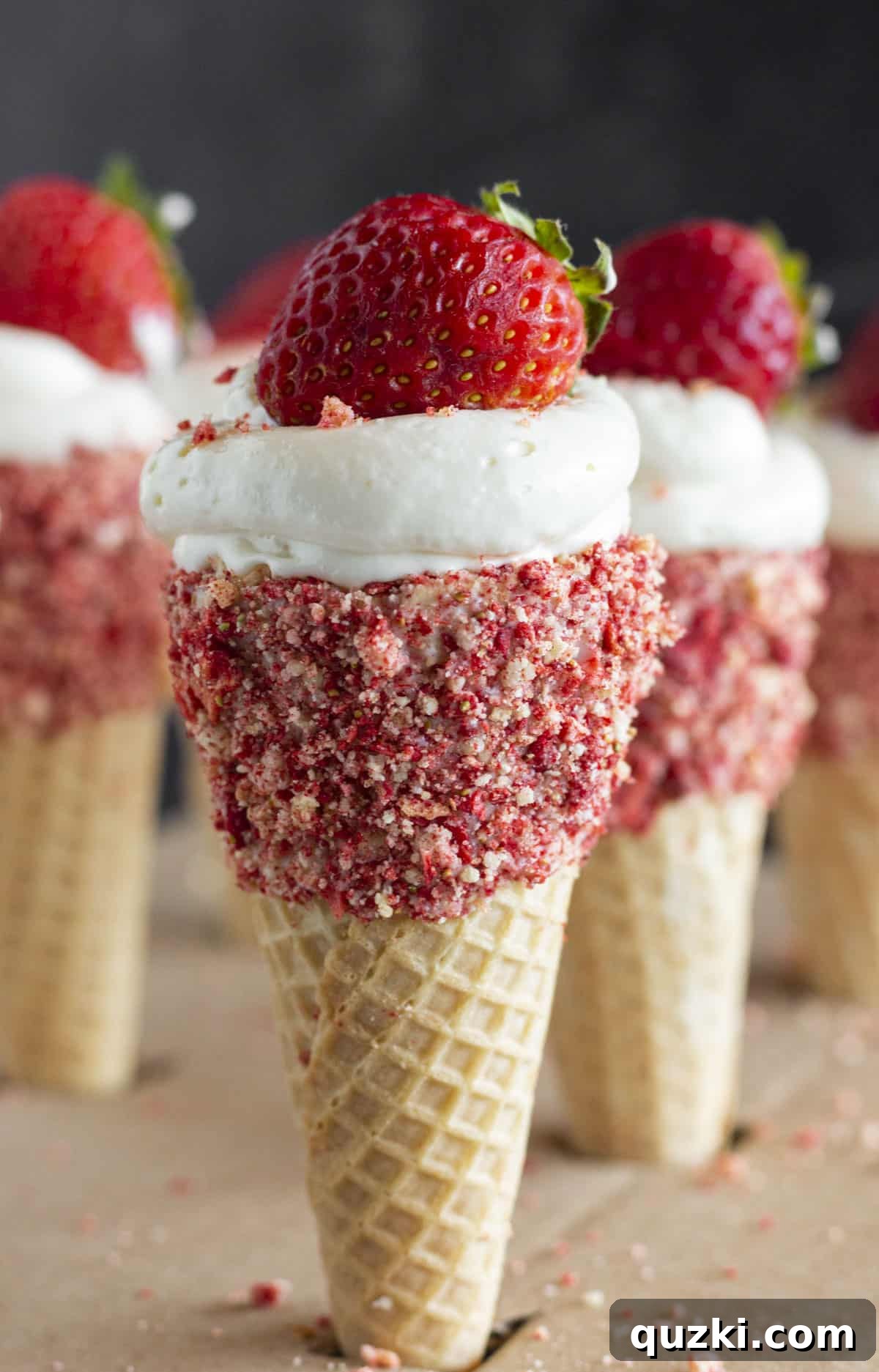 Six vibrant Strawberry Crunch Cheesecake Cones garnished with fresh strawberries, ready to be enjoyed.