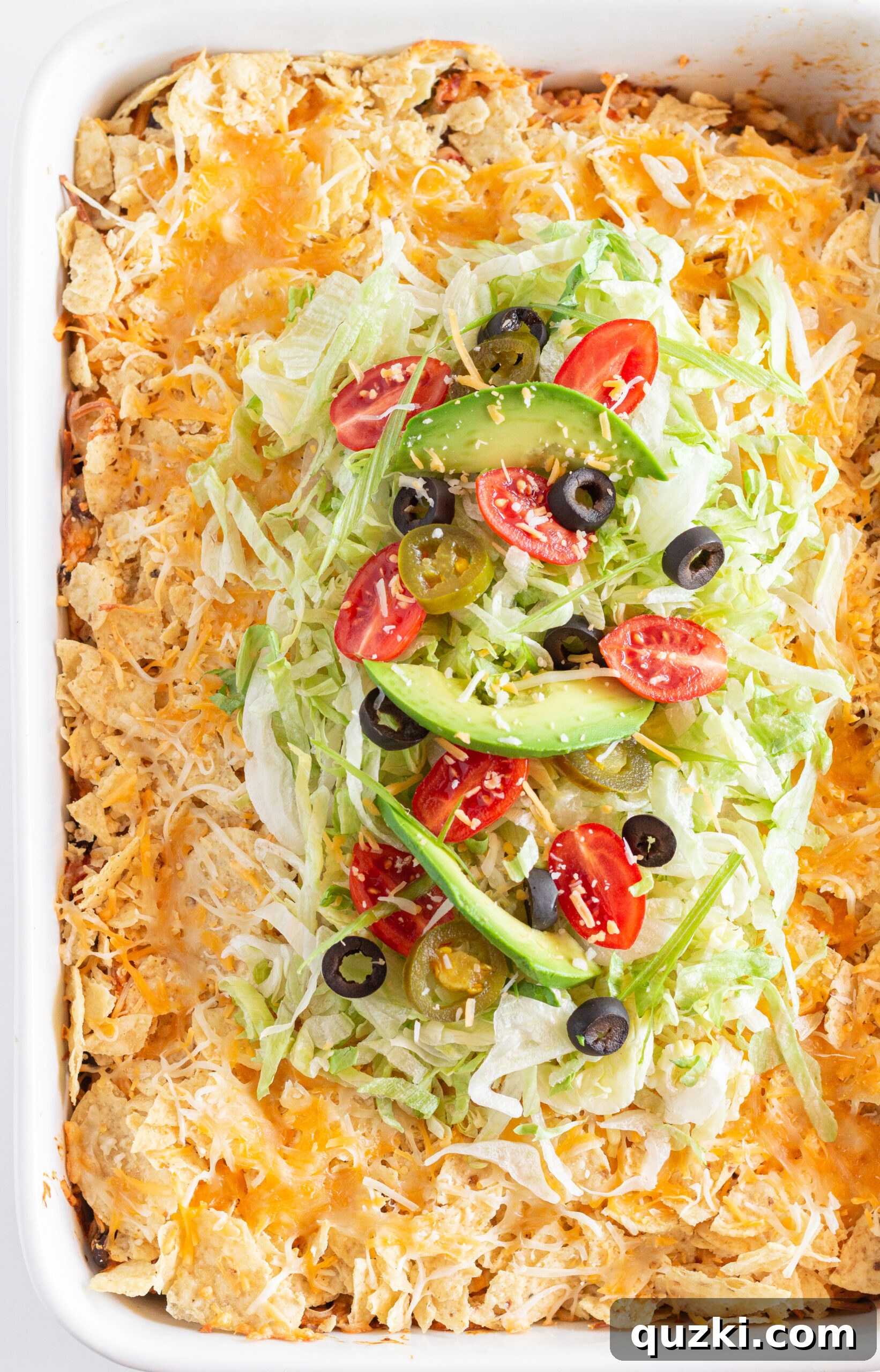 A close-up of Easy Chicken Taco Casserole, garnished with fresh cilantro and a dollop of sour cream.