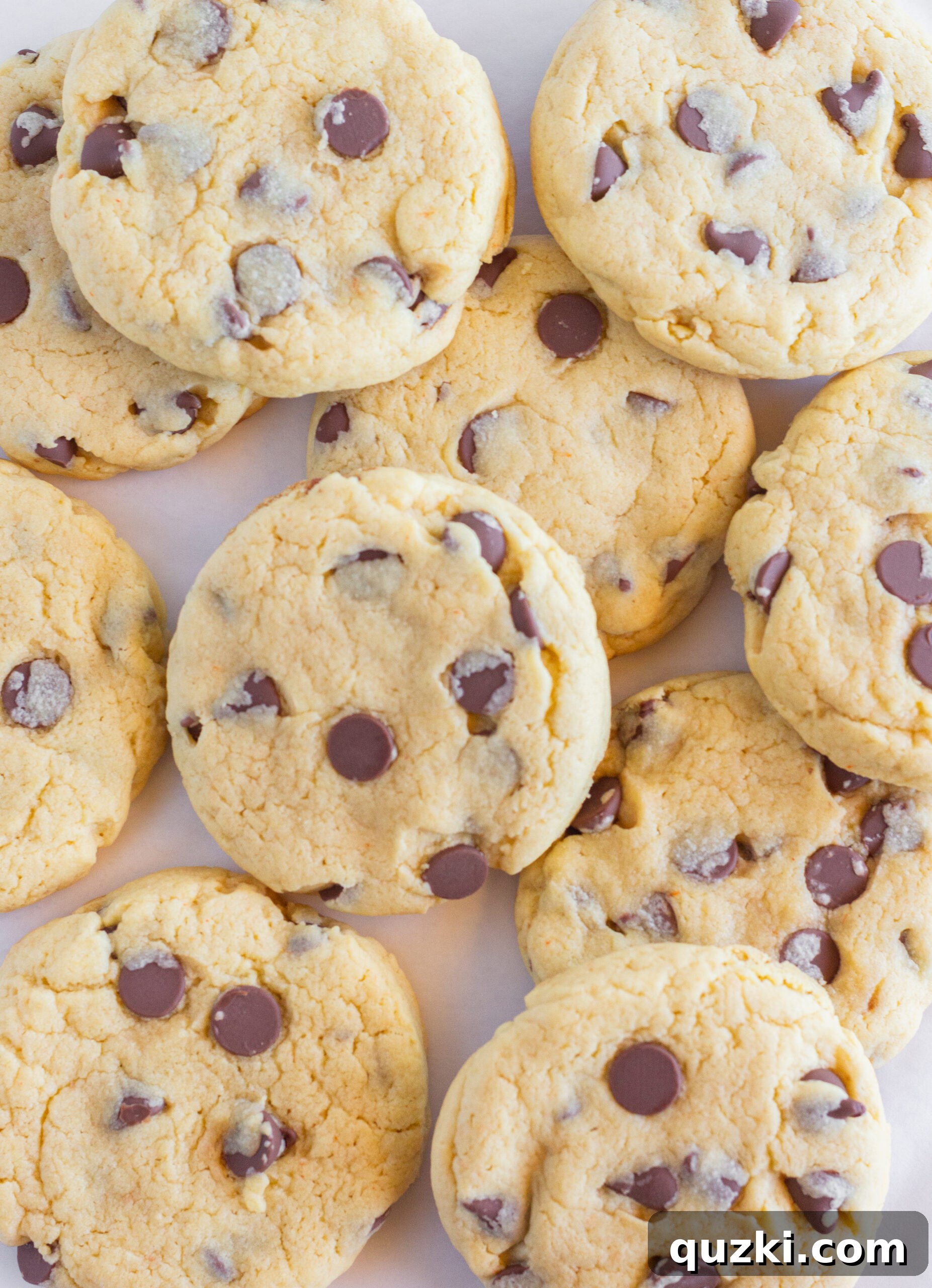 Various sizes and arrangements of Easy Chocolate Chip Cake Mix Cookies on a baking sheet, ready to be enjoyed