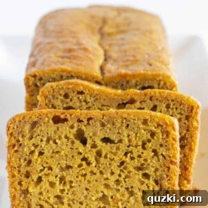 Cake Mix Shortcut Pumpkin Spice Loaf 7 A loaf of pumpkin bread with two slices cut, ready to serve.