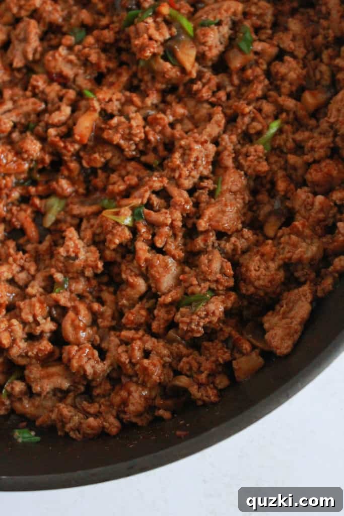 Vibrant Asian Turkey Lettuce Bites 6 The cooked ground turkey and mushroom mixture in a skillet, now coated with the rich Asian sauce, simmering gently to allow flavors to meld. Shows the final stage of the filling preparation.