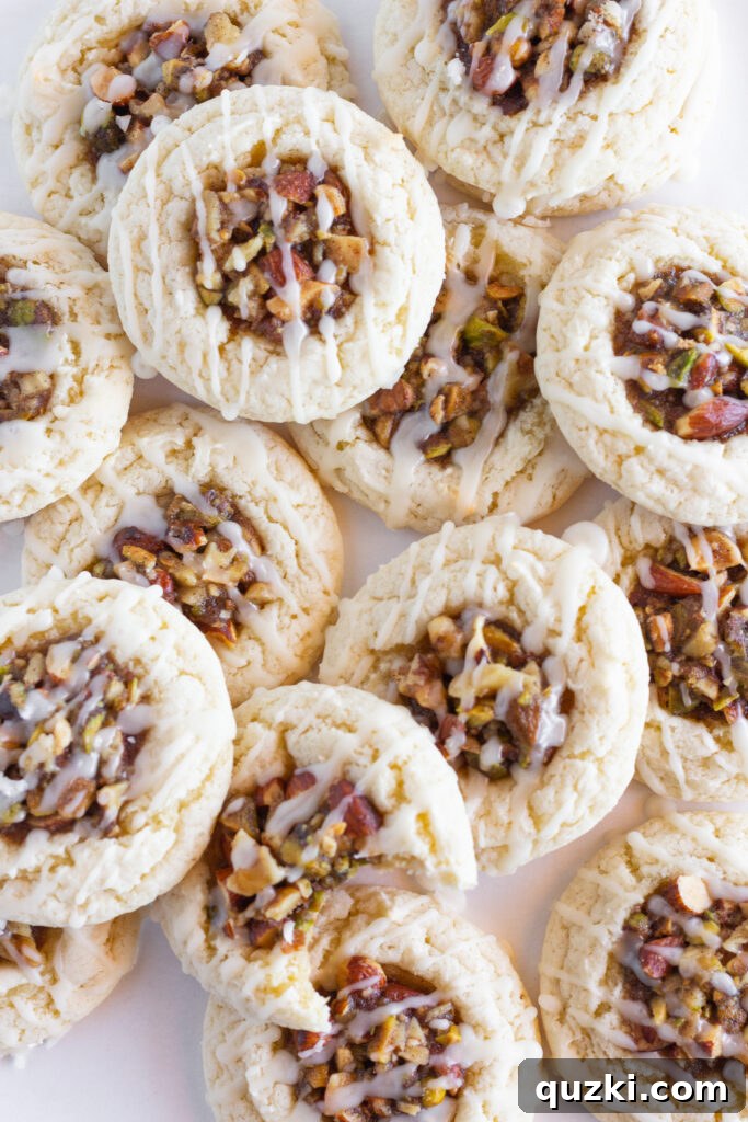 A large tray of Easy Baklava Cookies, freshly baked and still warm, with one cookie showing a perfect bite taken out of it. The golden brown edges and the rich, dark nut filling topped with a sweet glaze are clearly visible, inviting a taste.