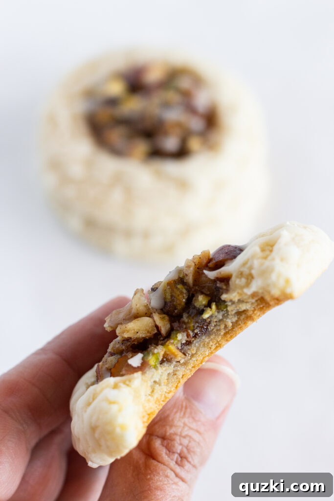 A close-up photo of a single Easy Baklava Cookie with a bite taken out of it, revealing the moist cookie base, the rich nut filling, and the glistening honey glaze. The texture and layers are clearly visible and highly appealing.