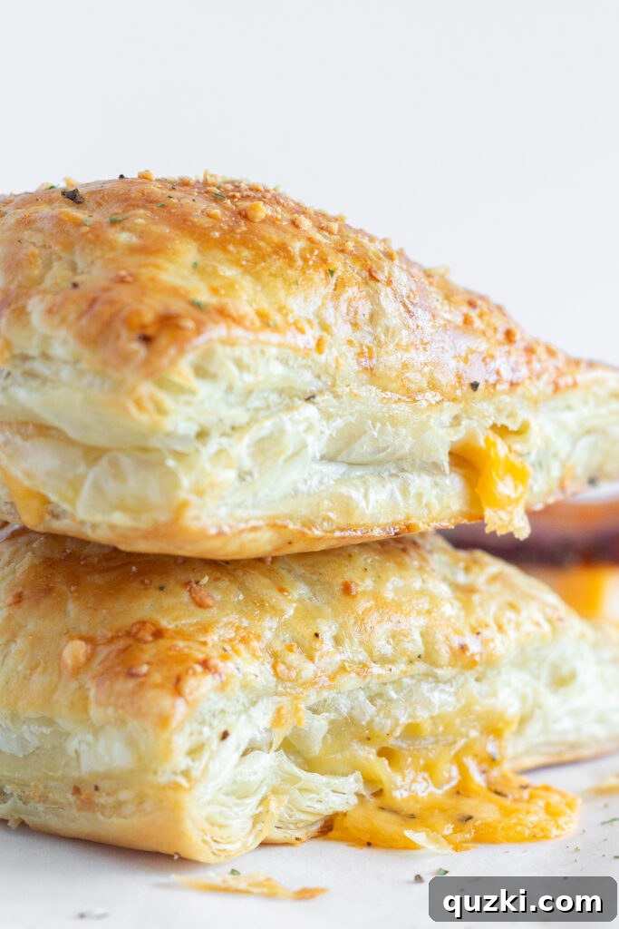 Two Bacon Turnovers stacked on top of each other on a plate, highlighting their appetizing appearance.
