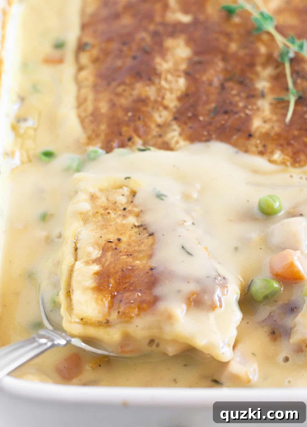 Serving a finished turkey pot pie with puff pastry, golden brown and steaming.