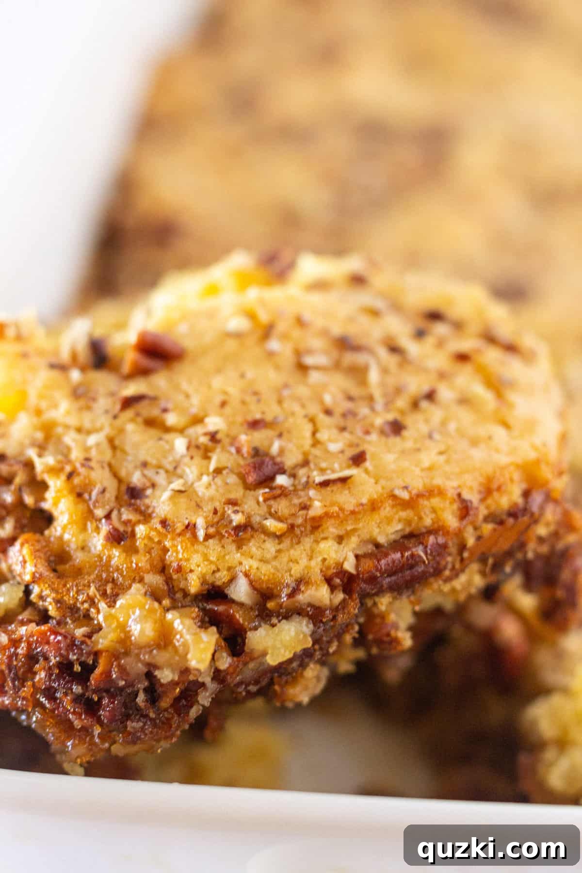 A generous scoop of delicious Pecan Pie Cobbler made with a cake mix, showcasing its gooey filling and tender topping.