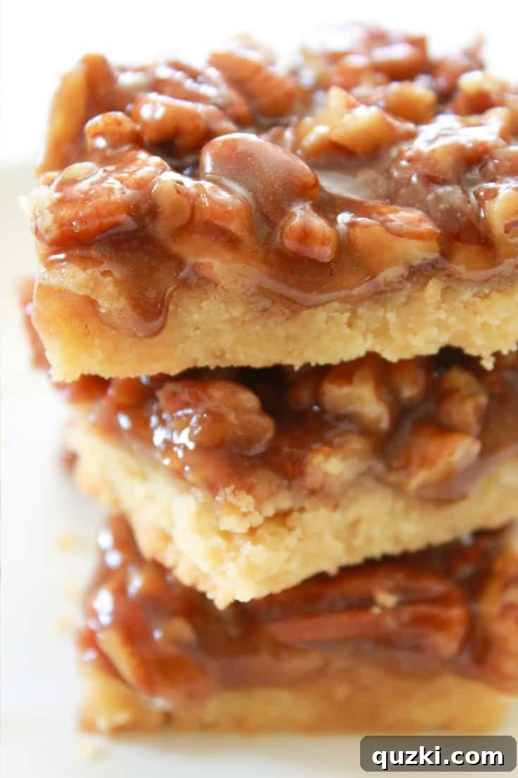 A neatly stacked trio of golden Pecan Shortbread Bars, showcasing their irresistible layers and tempting texture.