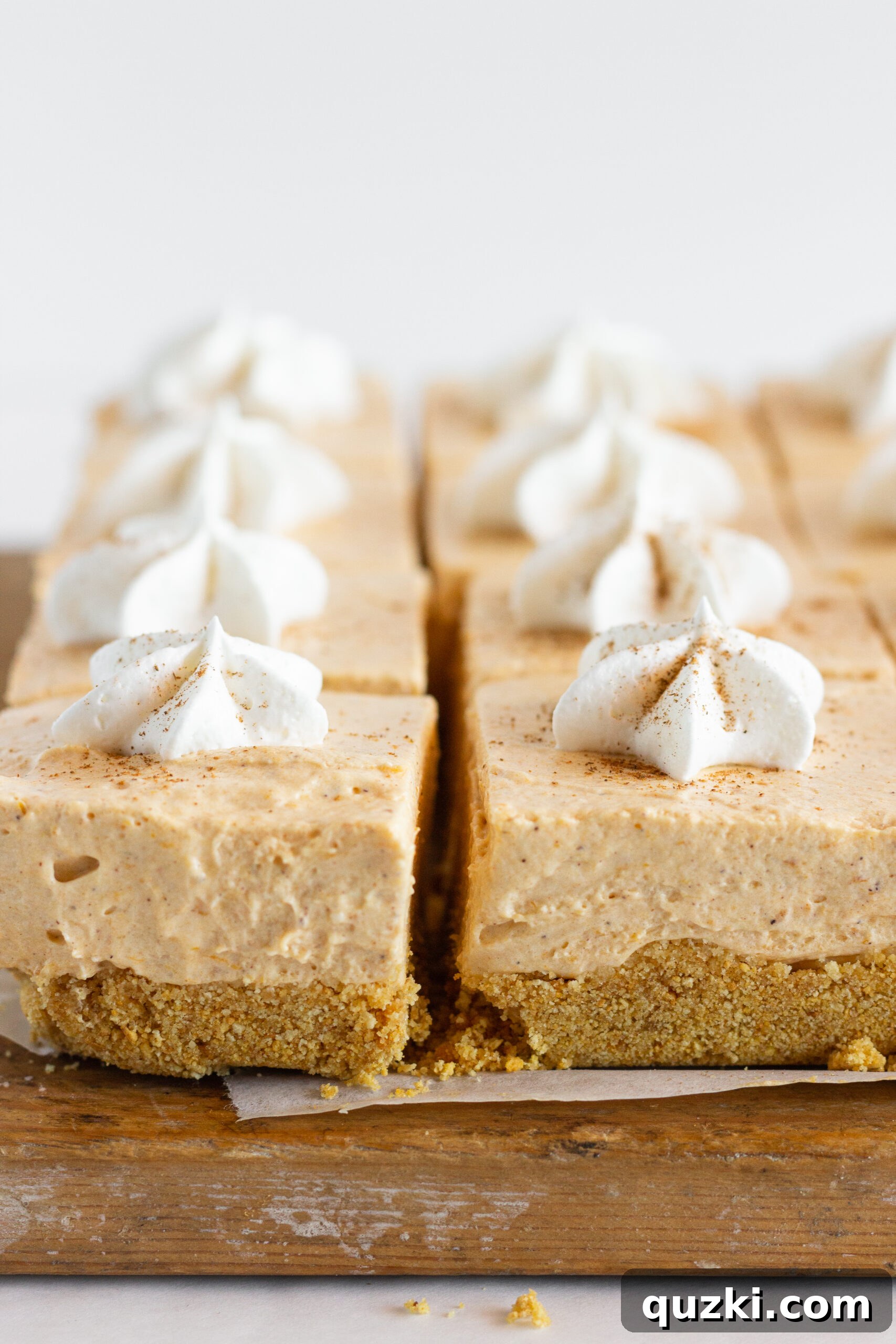 Pumpkin No Bake Cheesecake Bars, featuring a creamy pumpkin layer over a spiced crust, perfect for autumn holidays.