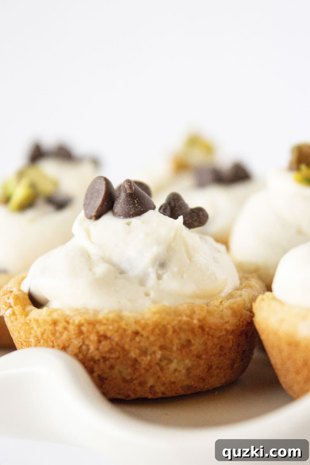 20 Festive Cake Mix Cookies Made Easy 14 Elegant Cannoli Cookie Cups, adorned with mini chocolate chips and finely chopped pistachios, beautifully presented on a pristine white cake plate.