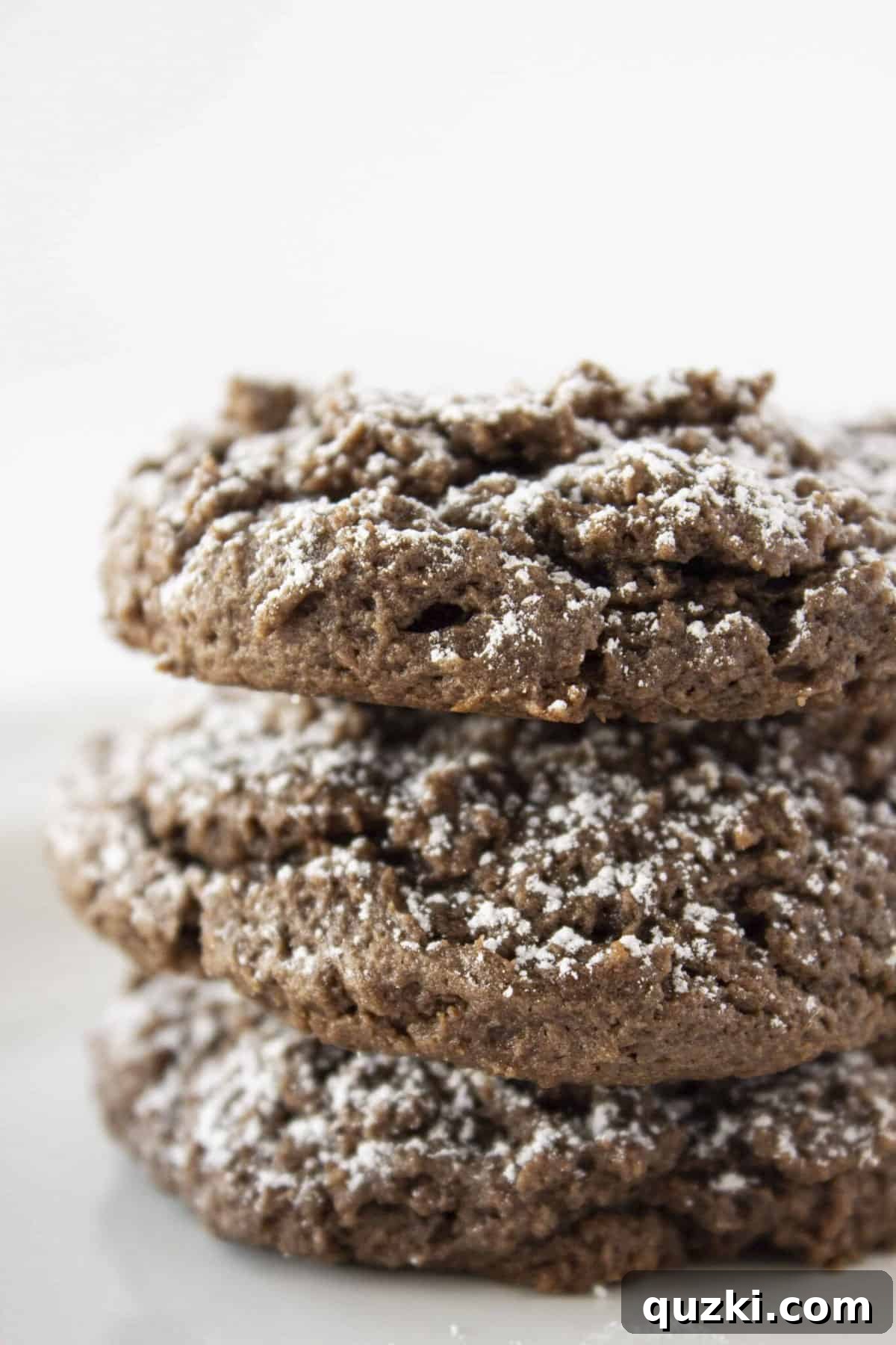 20 Festive Cake Mix Cookies Made Easy 15 A tempting stack of three soft and rich Chocolate Cream Cheese Cookies, lightly dusted with powdered sugar, ready to be enjoyed.