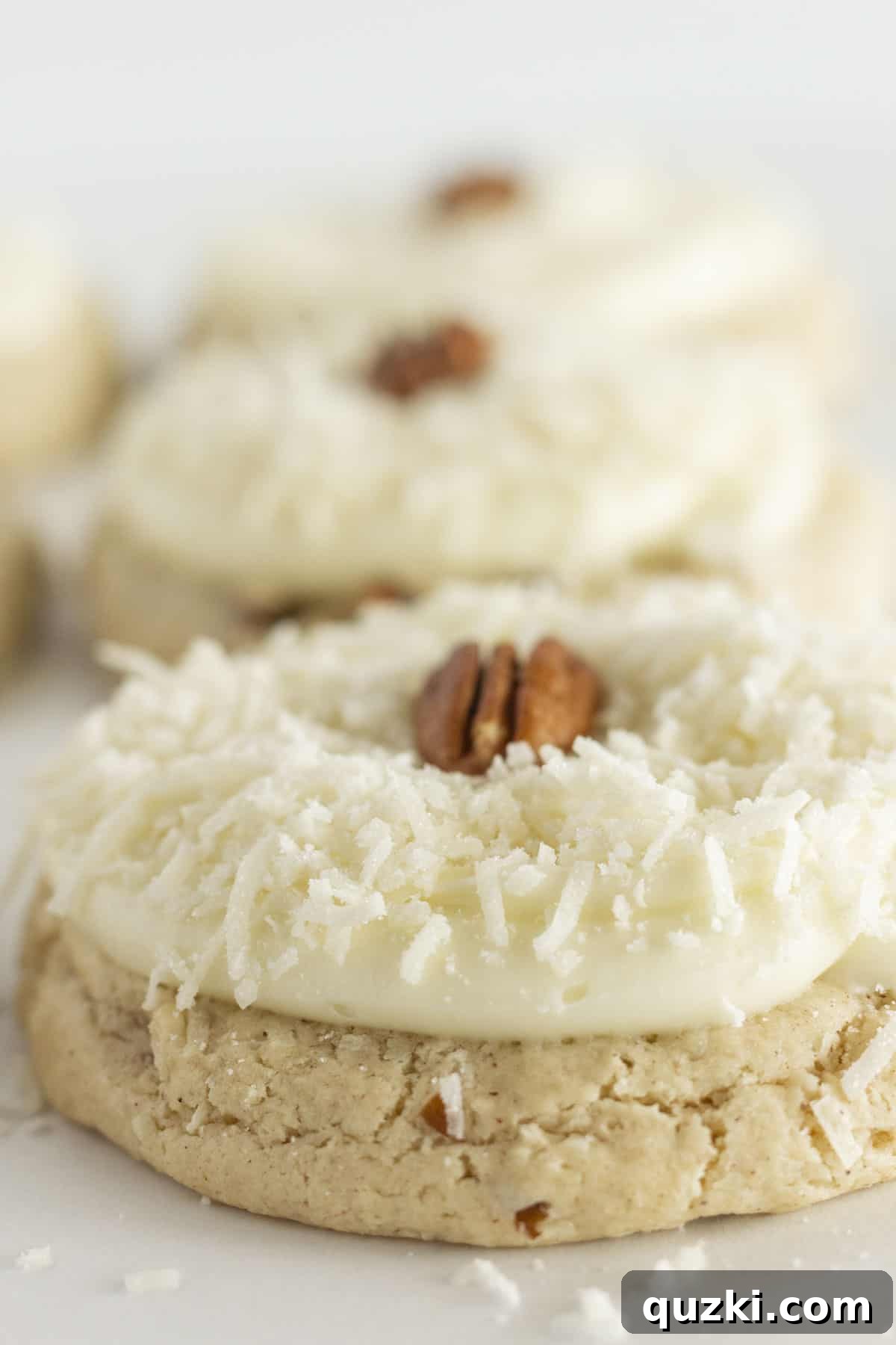 20 Festive Cake Mix Cookies Made Easy 19 A tempting display of six large Coconut Pecan Cookies, generously topped with creamy cream cheese frosting, inviting you to indulge.
