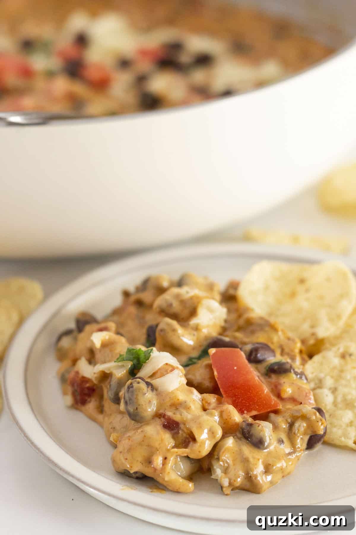 Serving Velveeta Queso with tortilla chips on a white ceramic plate.