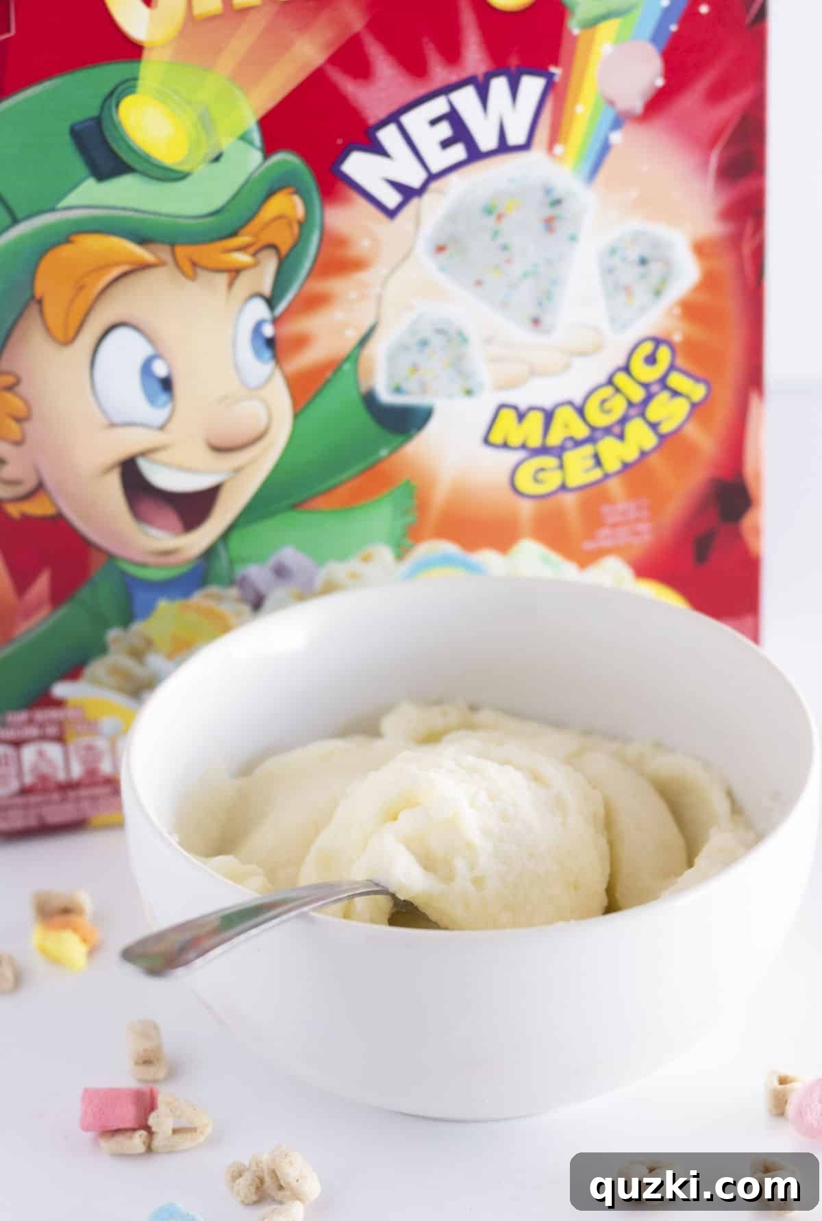 Cereal Milk Magic Frosting 2 A bowl of creamy cereal milk frosting with vibrant Lucky Charms marshmallows scattered in the background, hinting at the delightful flavor.