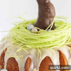 A pink velvet cake with edible grass and a chocolate bunny for Easter.