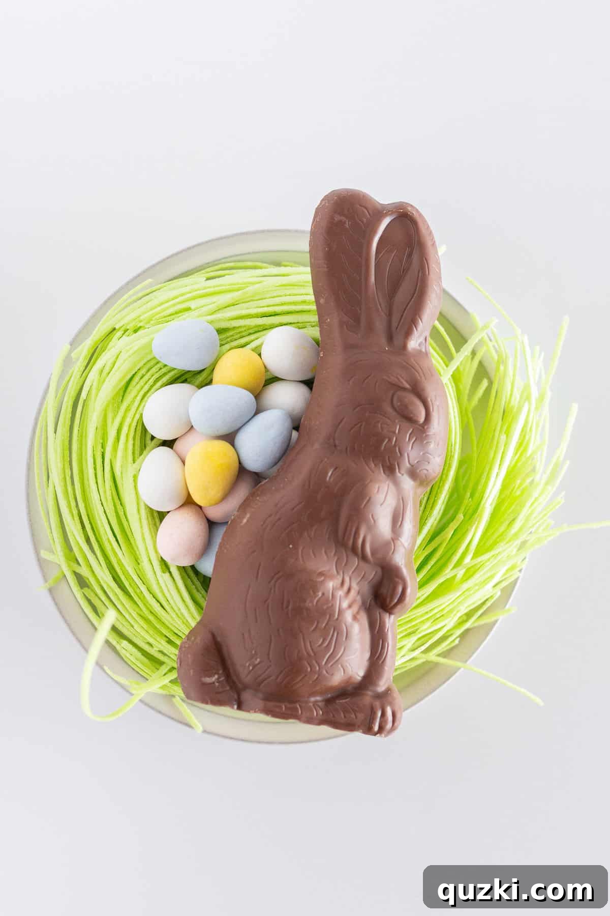 Effortless Easter Bundt Delight 5 A vibrant selection of Easter candy, including edible grass, Cadbury Mini Eggs, and a chocolate bunny, ready to adorn the cake.