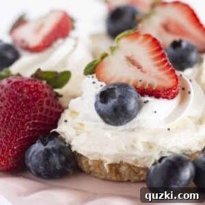 Four mini cheesecakes beautifully arranged with fresh fruit on a charming pink cake plate.