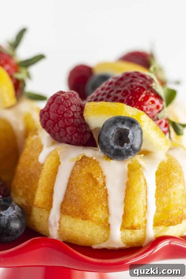 Adorable mini lemon bundt cakes, glazed and topped with fresh lemon zest, ideal for Mother's Day brunch.