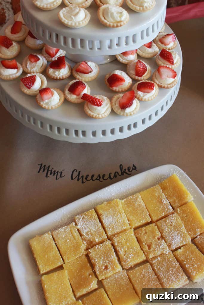 Host a Showstopping Dessert Buffet 11 Close-up of mini cheesecakes, some topped with strawberries, elegantly displayed on stacked cake plates.