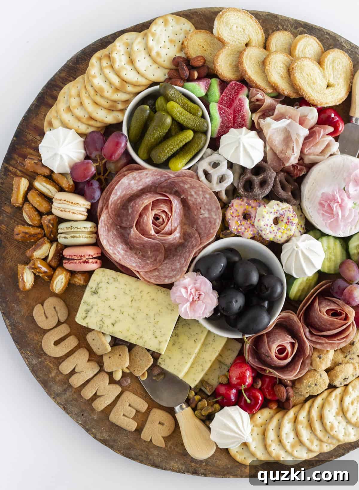 An overhead shot of a beautifully arranged summer charcuterie board, brimming with fresh fruits, cheeses, meats, and crackers.