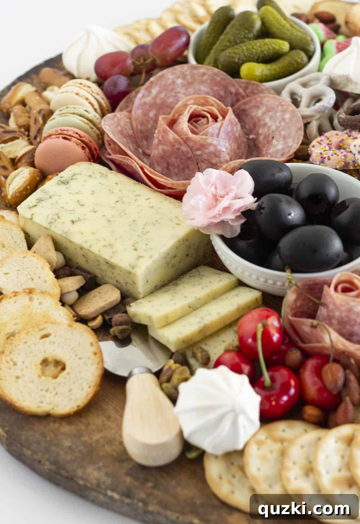 A close-up shot of an intricately folded salami rose on a bountiful summer charcuterie board.