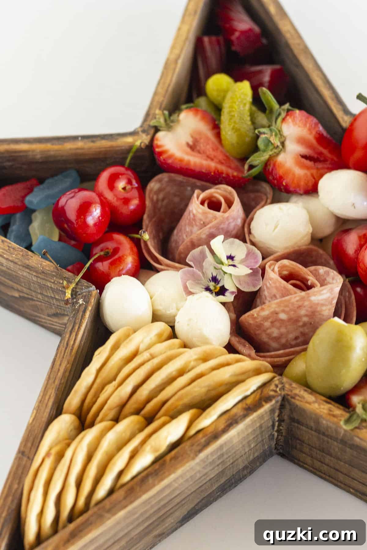 Star-Spangled Fourth of July Charcuterie 4 A close-up view of a star-shaped charcuterie board filled with festive red, white, and blue treats and snacks.