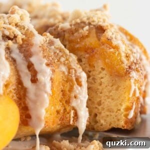 A beautifully decorated peach cobbler cake with a slice being served, revealing the luscious peach filling and crumbly texture.