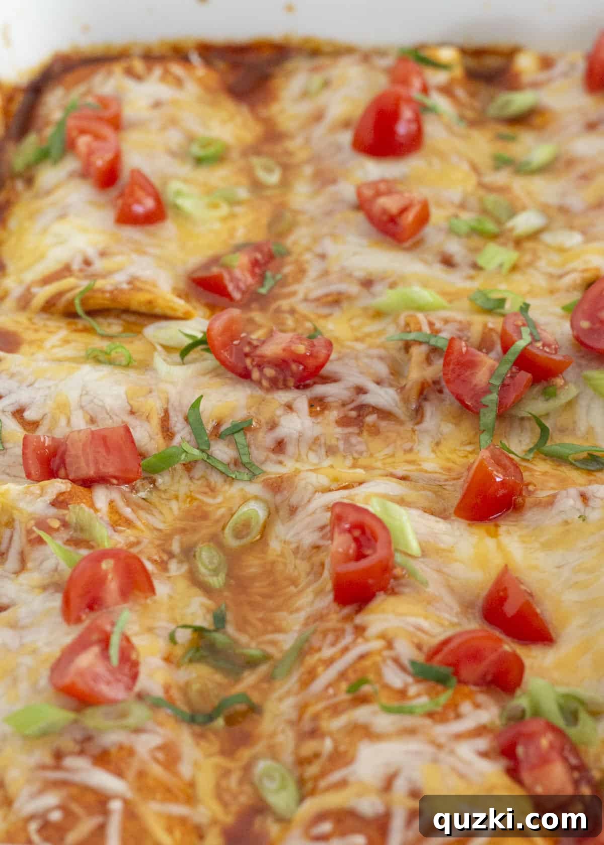 Frozen Burrito Fiesta Bake 7 A close-up of the baked frozen burrito casserole, garnished with freshly chopped tomatoes and sliced green onions, ready to be served.