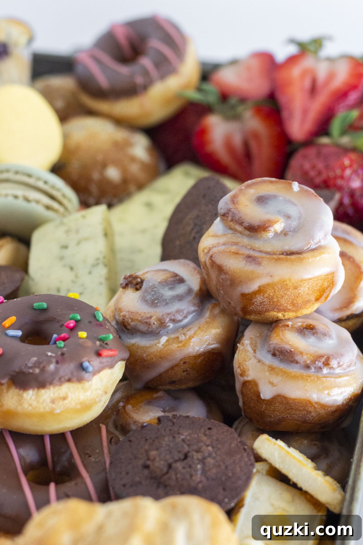 An up-close photo of a breakfast charcuterie board featuring an abundance of mini pastries, fruits, and small treats.