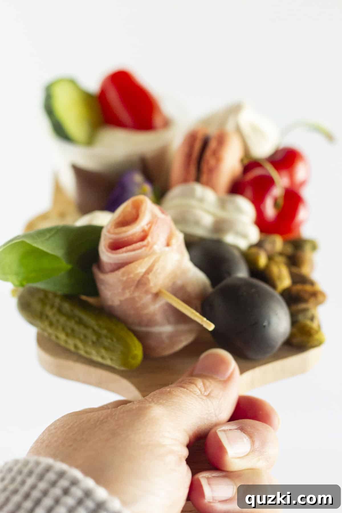 Build a Beautiful Personal Charcuterie Board 4 A hand holding a perfectly curated mini charcuterie board, ready for serving.