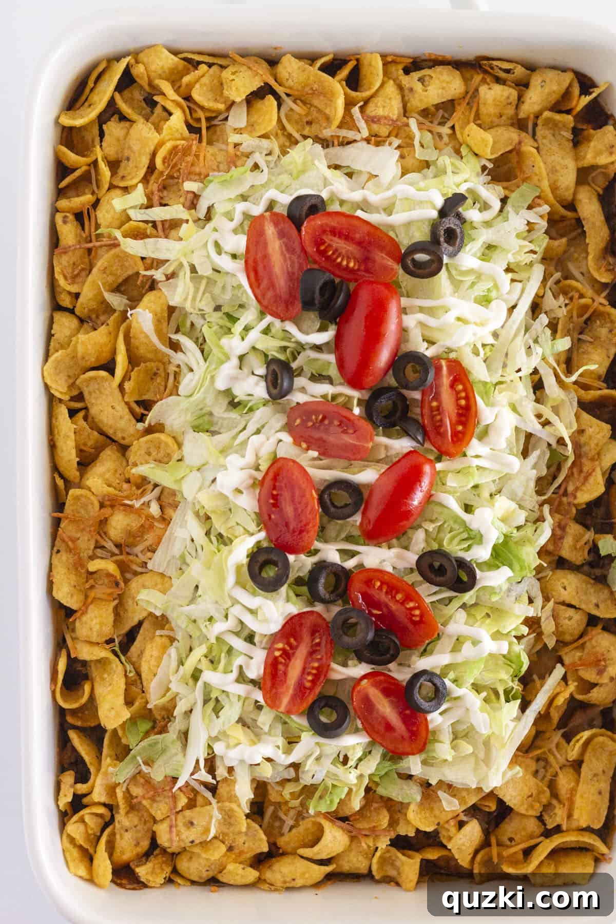 A top-down view of a perfectly baked, whole Walking Taco Casserole in a baking dish, ready to be served.
