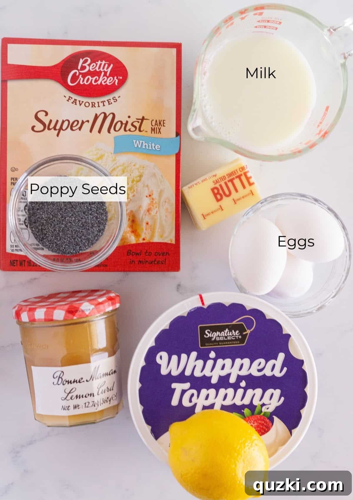 A flat lay photograph displaying all the fresh ingredients needed for baking a delicious lemon curd cake, including lemons, eggs, milk, butter, a cake mix box, and a jar of lemon curd.